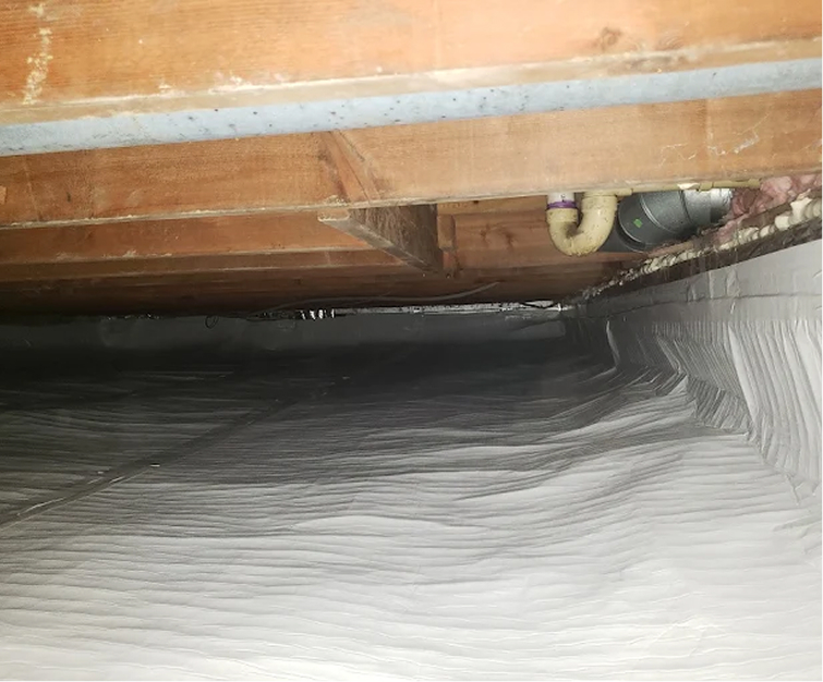 Foundation Solutions 360 technician inspecting a residential crawl space
